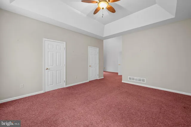 a view of an empty room with a ceiling fan