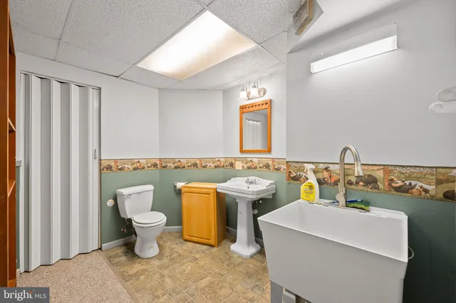 a bathroom with a toilet sink and mirror