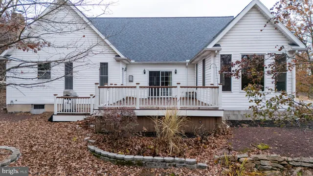 a view of a house with a wooden deck and furniture