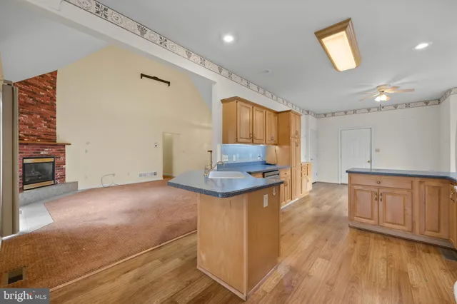 a kitchen with granite countertop a stove cabinets and wooden floor