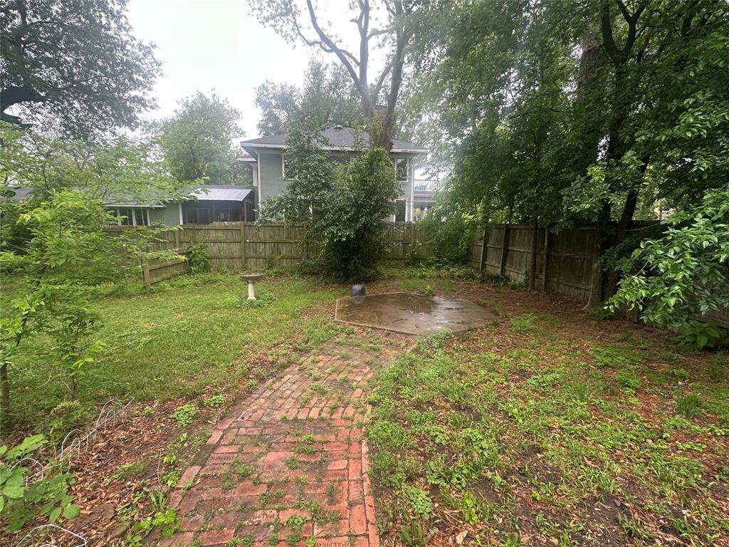 504 1st Street Terrell, TX 75160 - Photo 27 of 27 Fenced backyard featuring a brick pathway, concrete pad, and mature trees