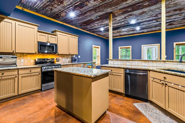 a bedroom with a bed next to a window with a flat screen tv