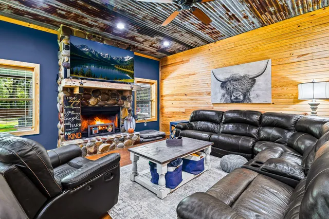 a living room with furniture a fireplace and a flat screen tv