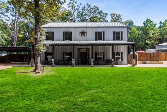 a view of a house with a yard and a large tree