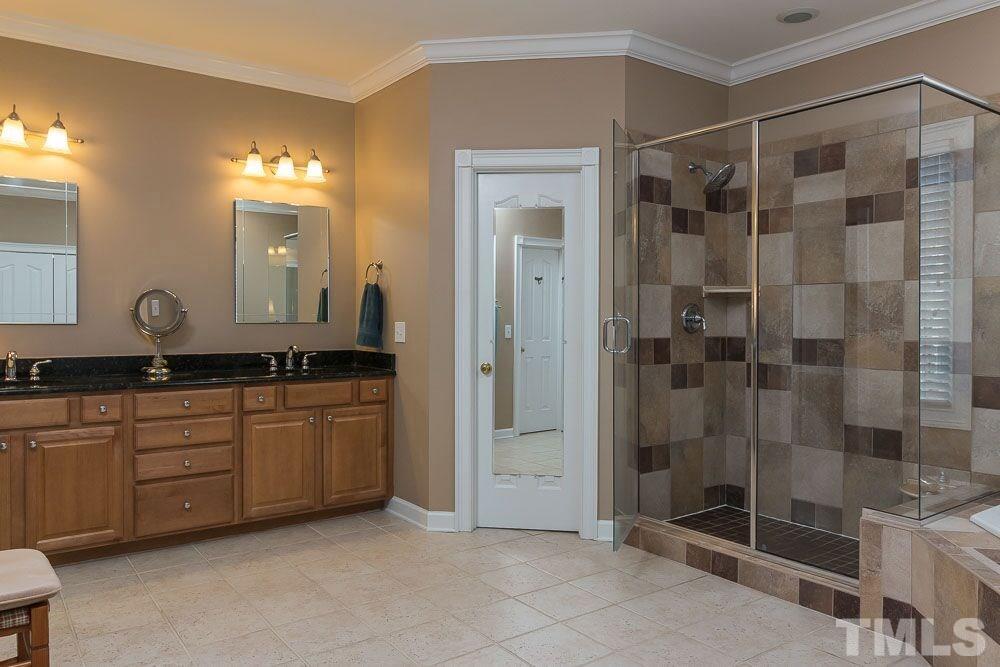 3920 Bentley Bridge Road Raleigh, NC 27612 - Photo 11 of 20 a bathroom with a shower and a sink a mirror