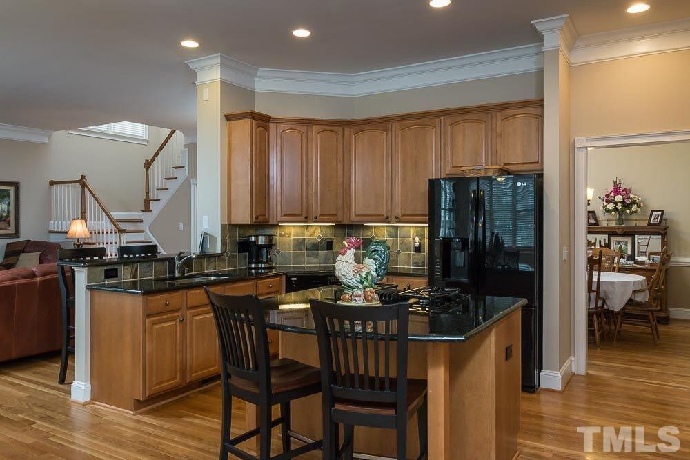 3920 Bentley Bridge Road Raleigh, NC 27612 - Photo 13 of 20 a kitchen with a table chairs stove and refrigerator