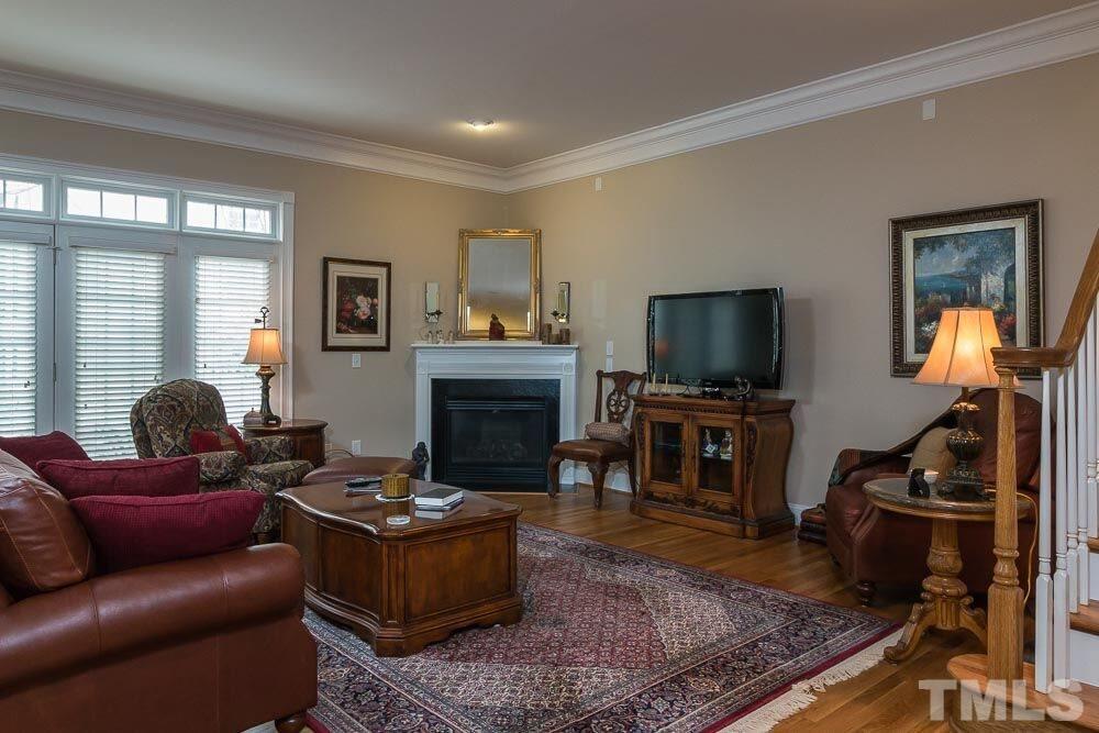 3920 Bentley Bridge Road Raleigh, NC 27612 - Photo 17 of 20 a living room with furniture a flat screen tv and a fireplace