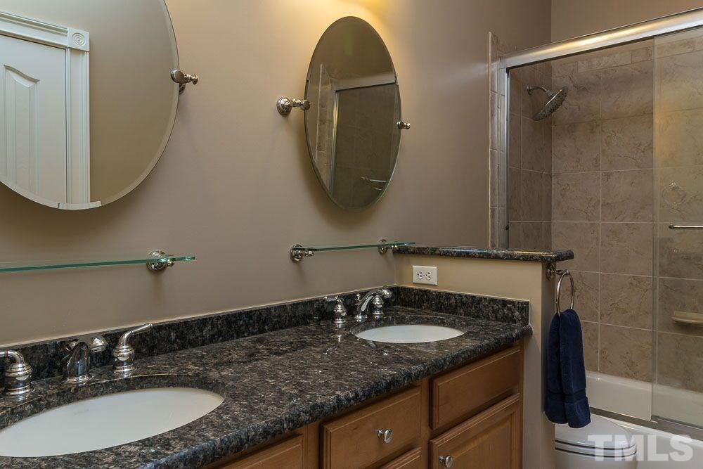 3920 Bentley Bridge Road Raleigh, NC 27612 - Photo 8 of 20 a bathroom with a granite countertop sink a mirror and a shower