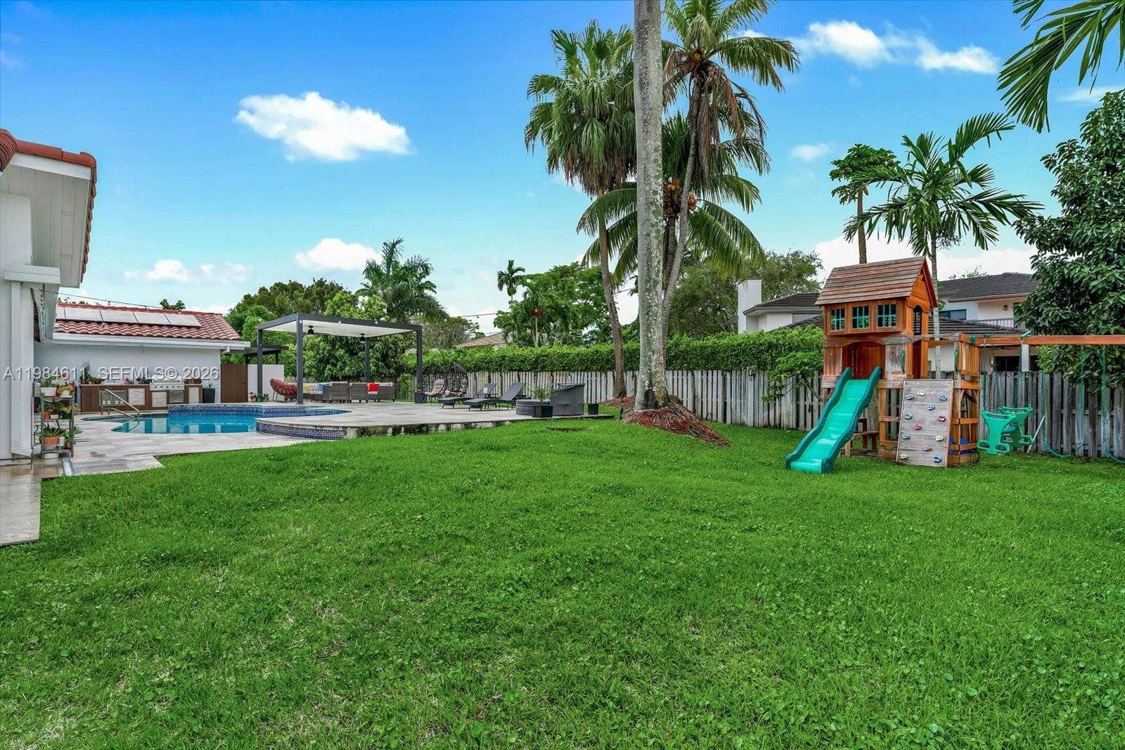 10126 Southwest 93rd Place Miami, FL 33176 - Photo 18 of 27 a view of a house with a yard and palm trees