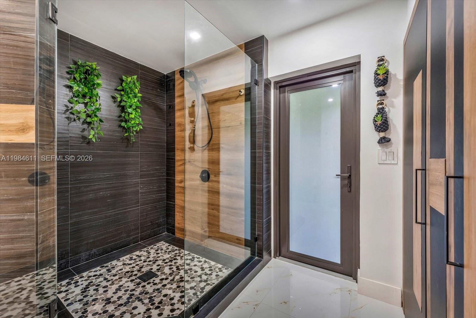 10126 Southwest 93rd Place Miami, FL 33176 - Photo 24 of 27 a bathroom with a glass shower door and a window