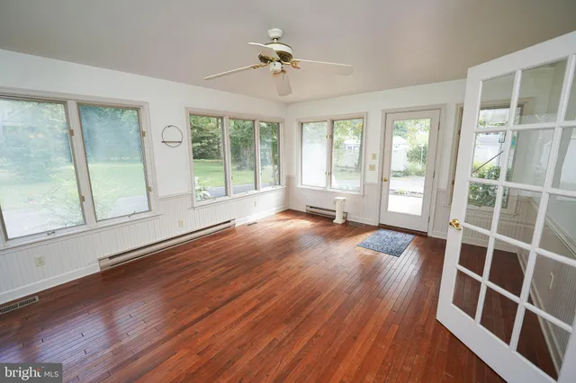 an empty room with wooden floor and windows