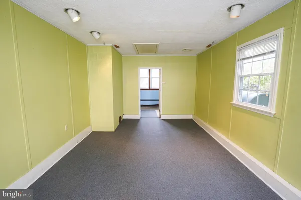 an empty room with wooden floor ceiling fan and windows