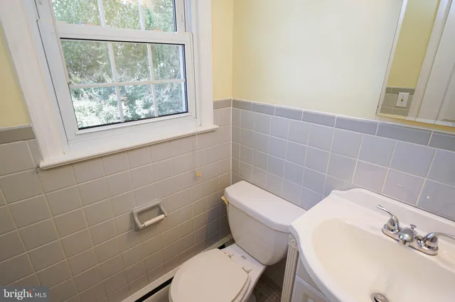 an empty room with wooden floor chandelier fan and windows