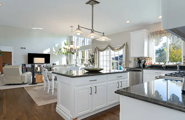 a kitchen with granite countertop a sink stove and cabinets