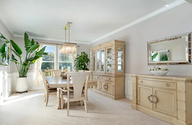 a dining room with furniture a chandelier and window