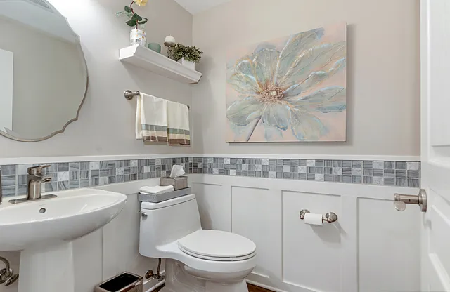 a bathroom with a toilet a sink and mirror