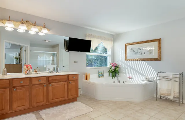 a large bathroom with a tub sink and mirror