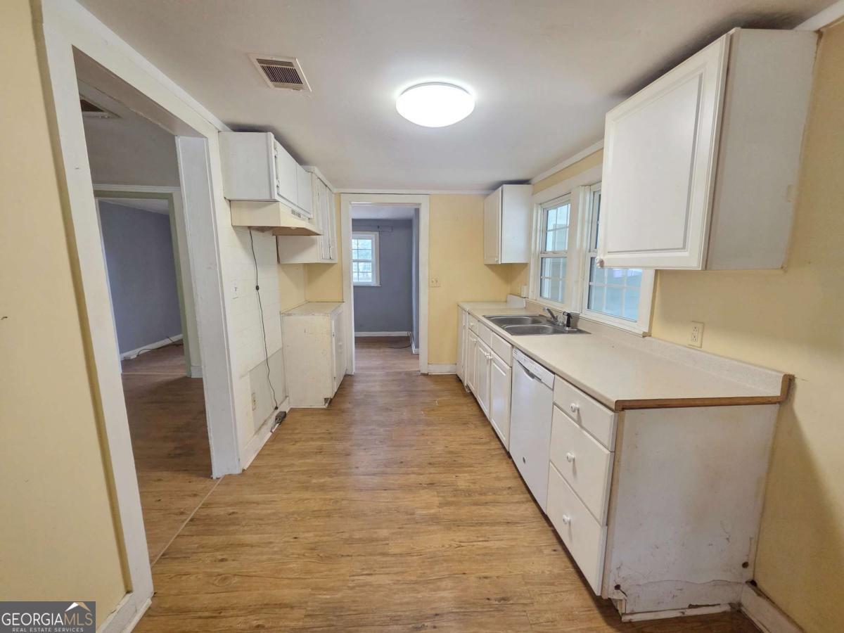 188 Holmesville Road Baxley, GA 31513 - Photo 5 of 20 a kitchen with white cabinets and sink