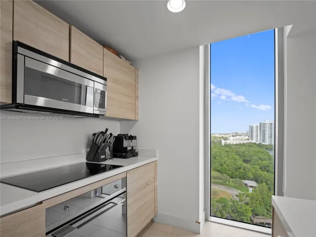 a view of an empty room with a floor to ceiling window and a larger window