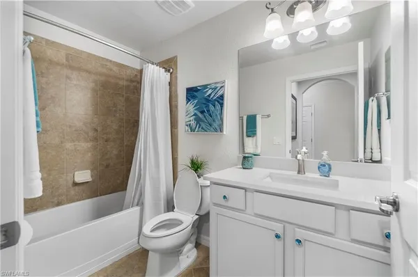 a bathroom with a sink a toilet and a large mirror