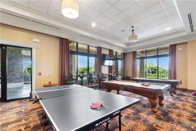 a room with pool table and windows