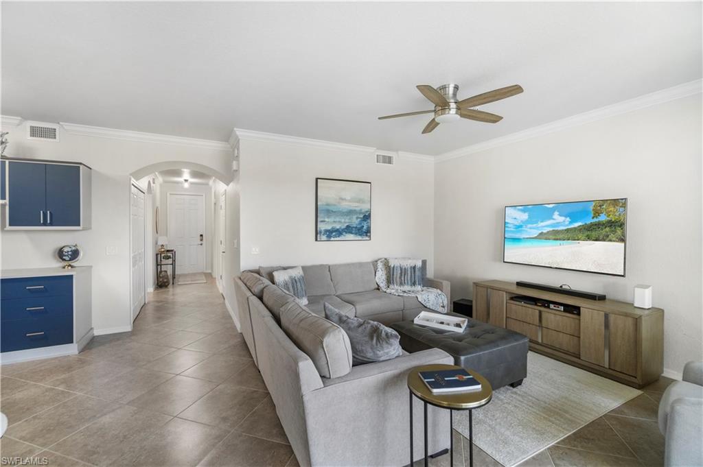 9820 Giaveno Circle, Unit 1422 Naples, FL 34113 - Photo 3 of 36 a living room with furniture and a flat screen tv