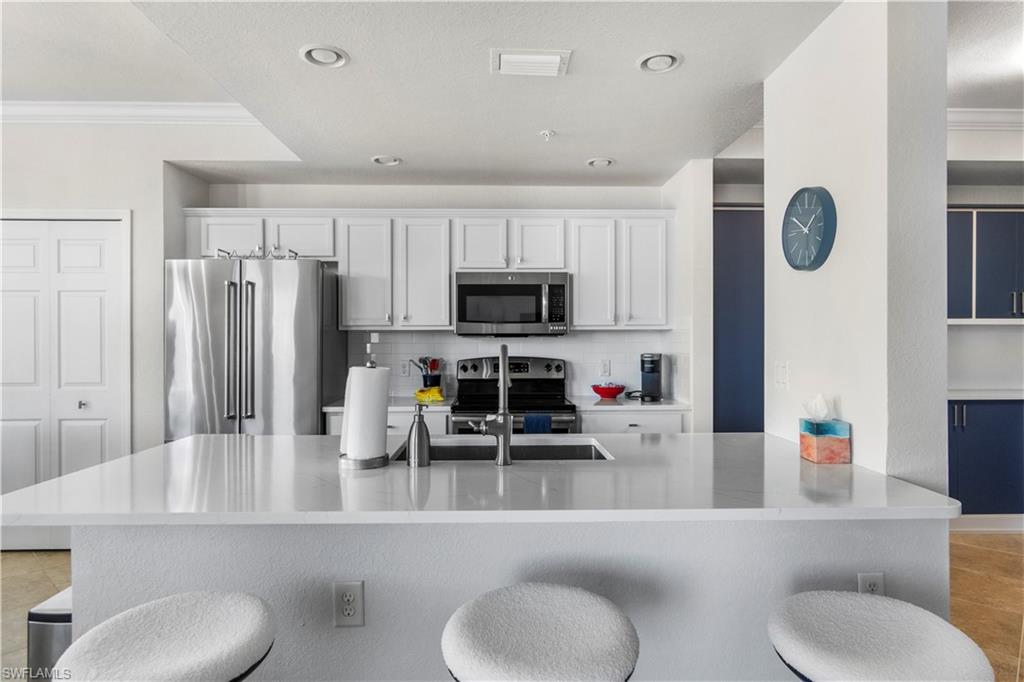 9820 Giaveno Circle, Unit 1422 Naples, FL 34113 - Photo 5 of 36 a living room with furniture and a flat screen tv