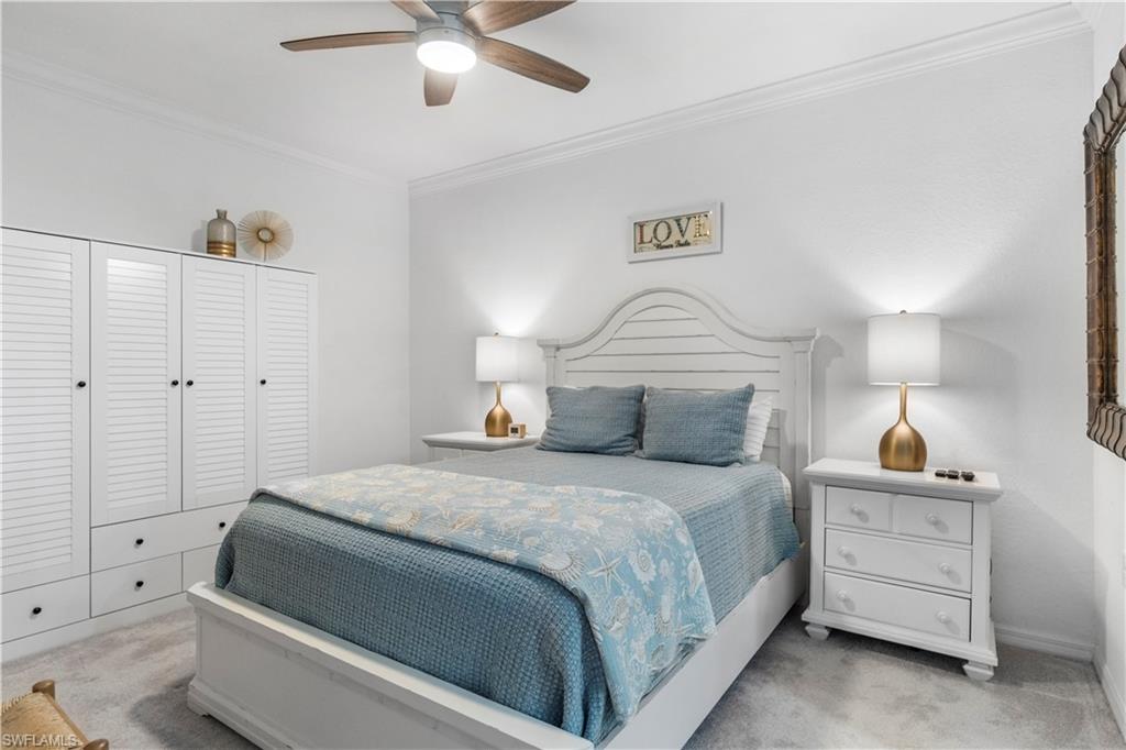 9820 Giaveno Circle, Unit 1422 Naples, FL 34113 - Photo 9 of 36 a bedroom with a bed and a lamp