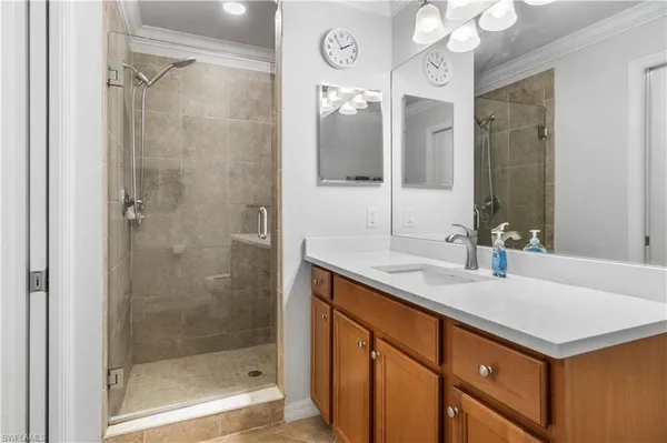 a bathroom with a sink vanity granite shower and a mirror
