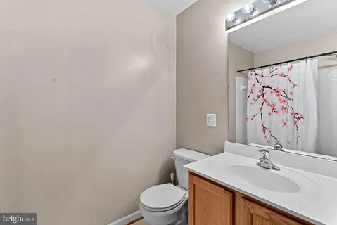 a view of an empty room with stairs and a window