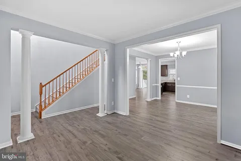 a view of a dining room with furniture a chandelier and wooden floor