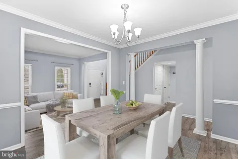 a view of an empty room with wooden floor and a chandelier