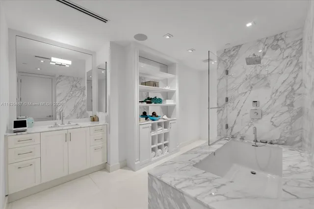 a bathroom with a granite countertop sink mirror and a bathtub
