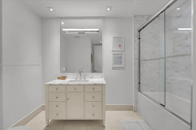 a spacious bathroom with a granite countertop sink mirror and a bathtub