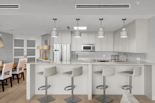 a kitchen with kitchen island granite countertop wooden cabinets and refrigerator