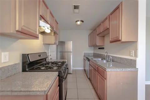 a kitchen with stainless steel appliances granite countertop a sink stove and refrigerator