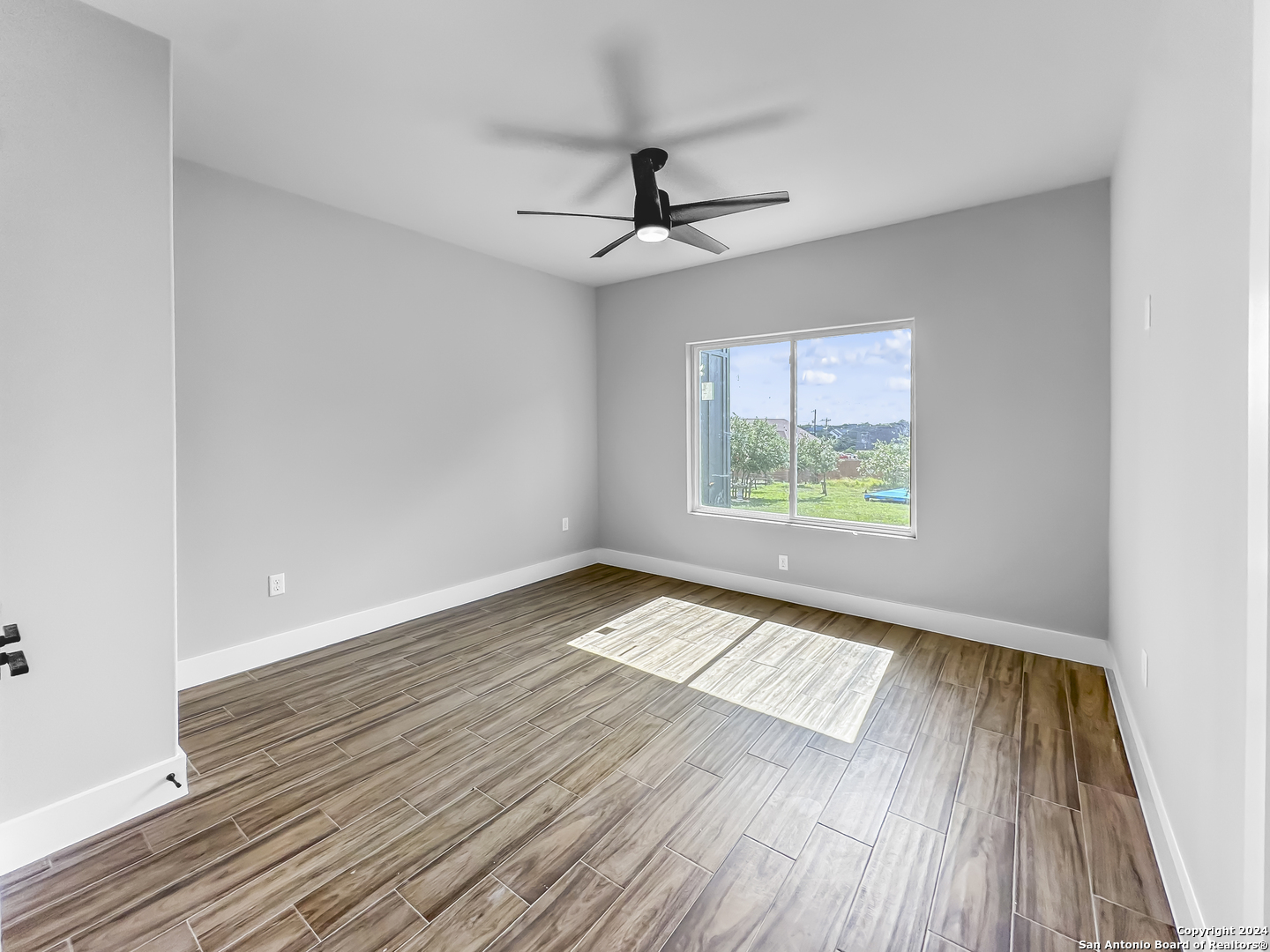 301 Hiram Cook Blanco, TX 78606 - Photo 11 of 16 wooden floor in an empty room with a window