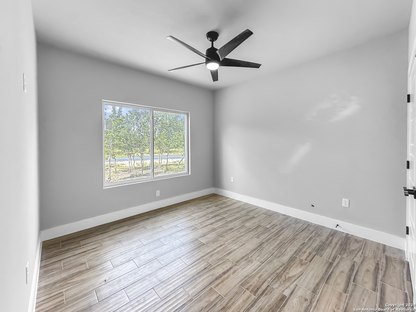 301 Hiram Cook Blanco, TX 78606 - Photo 12 of 16 wooden floor in an empty room with a window