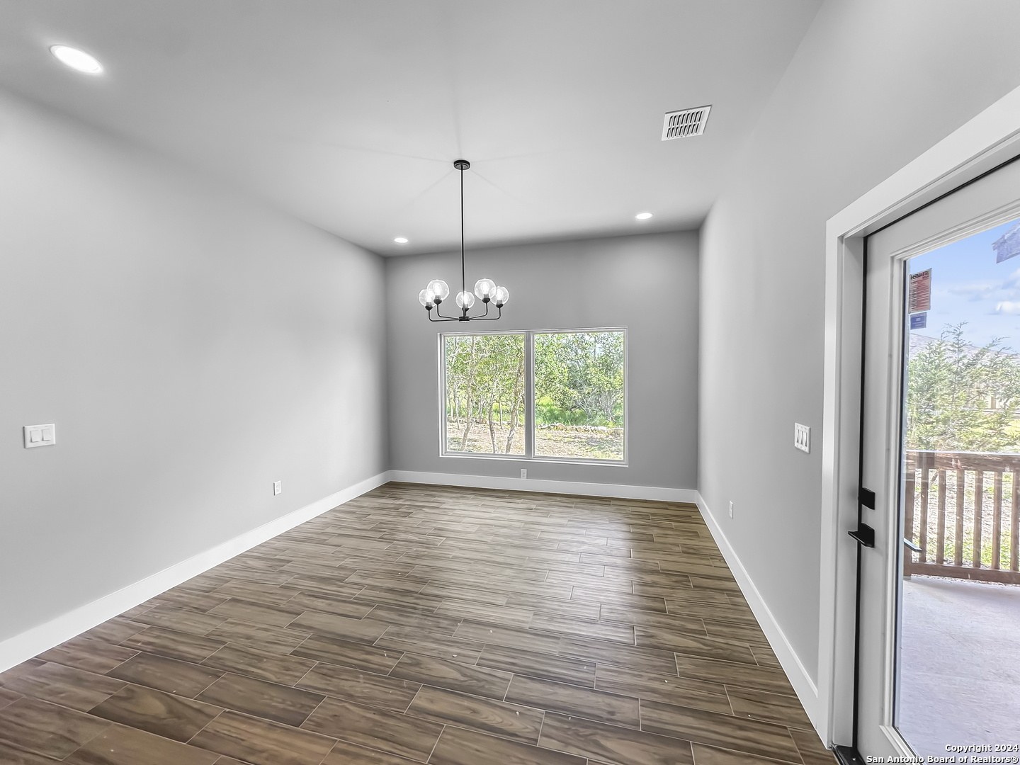 301 Hiram Cook Blanco, TX 78606 - Photo 6 of 16 an empty room with wooden floor and windows
