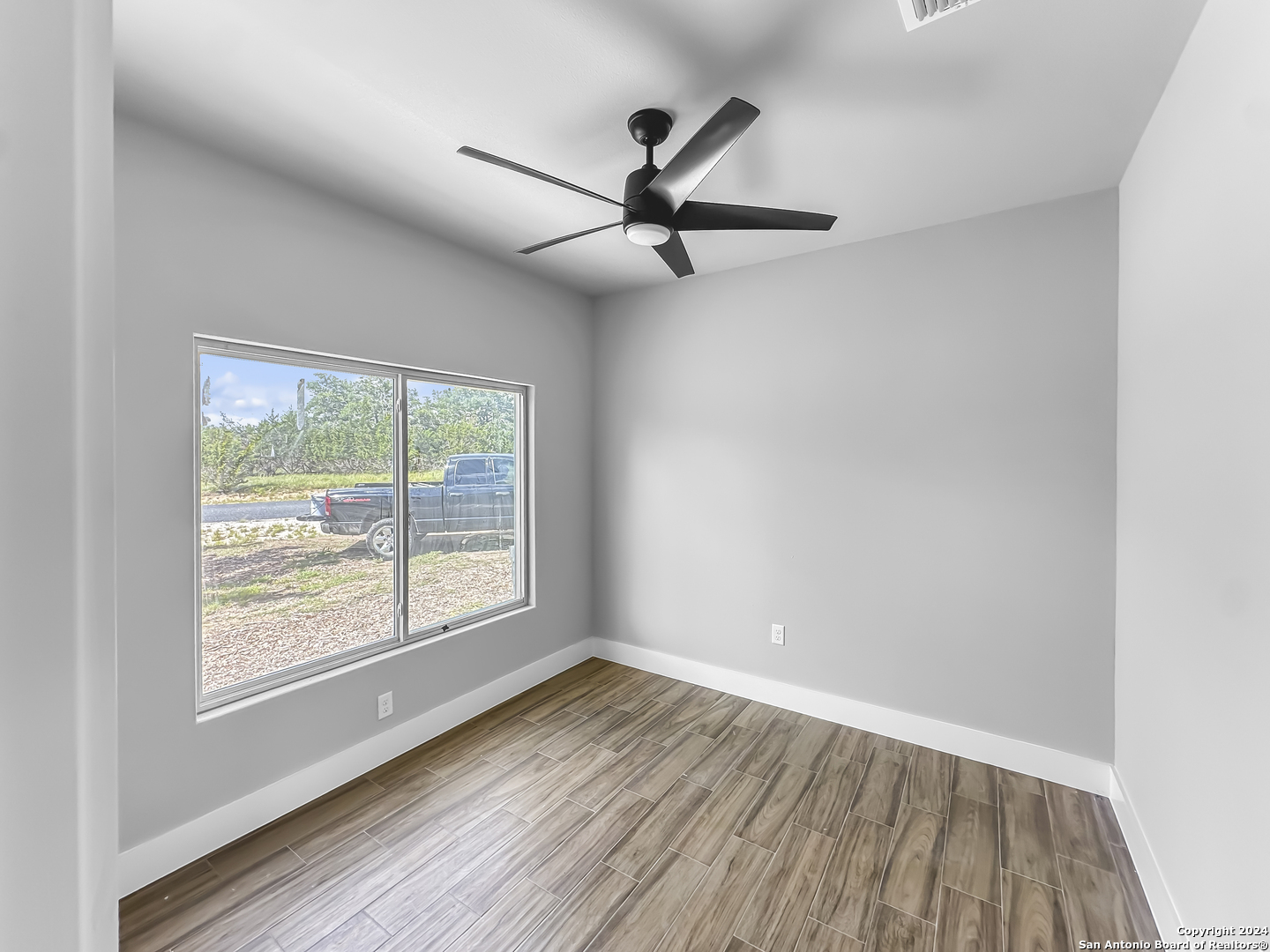 301 Hiram Cook Blanco, TX 78606 - Photo 7 of 16 an empty room with wooden floor and windows