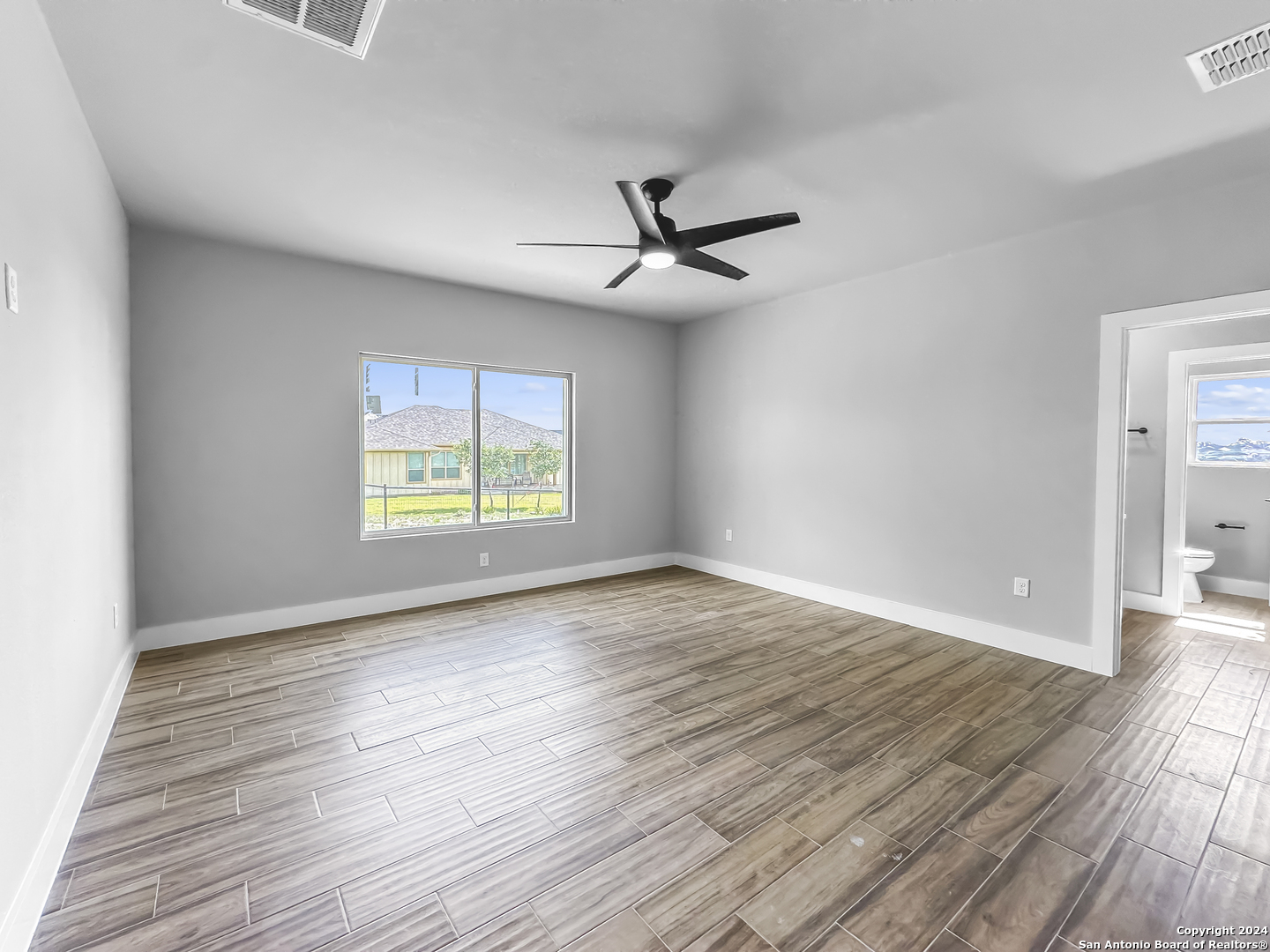 301 Hiram Cook Blanco, TX 78606 - Photo 8 of 16 wooden floor in an empty room with a window