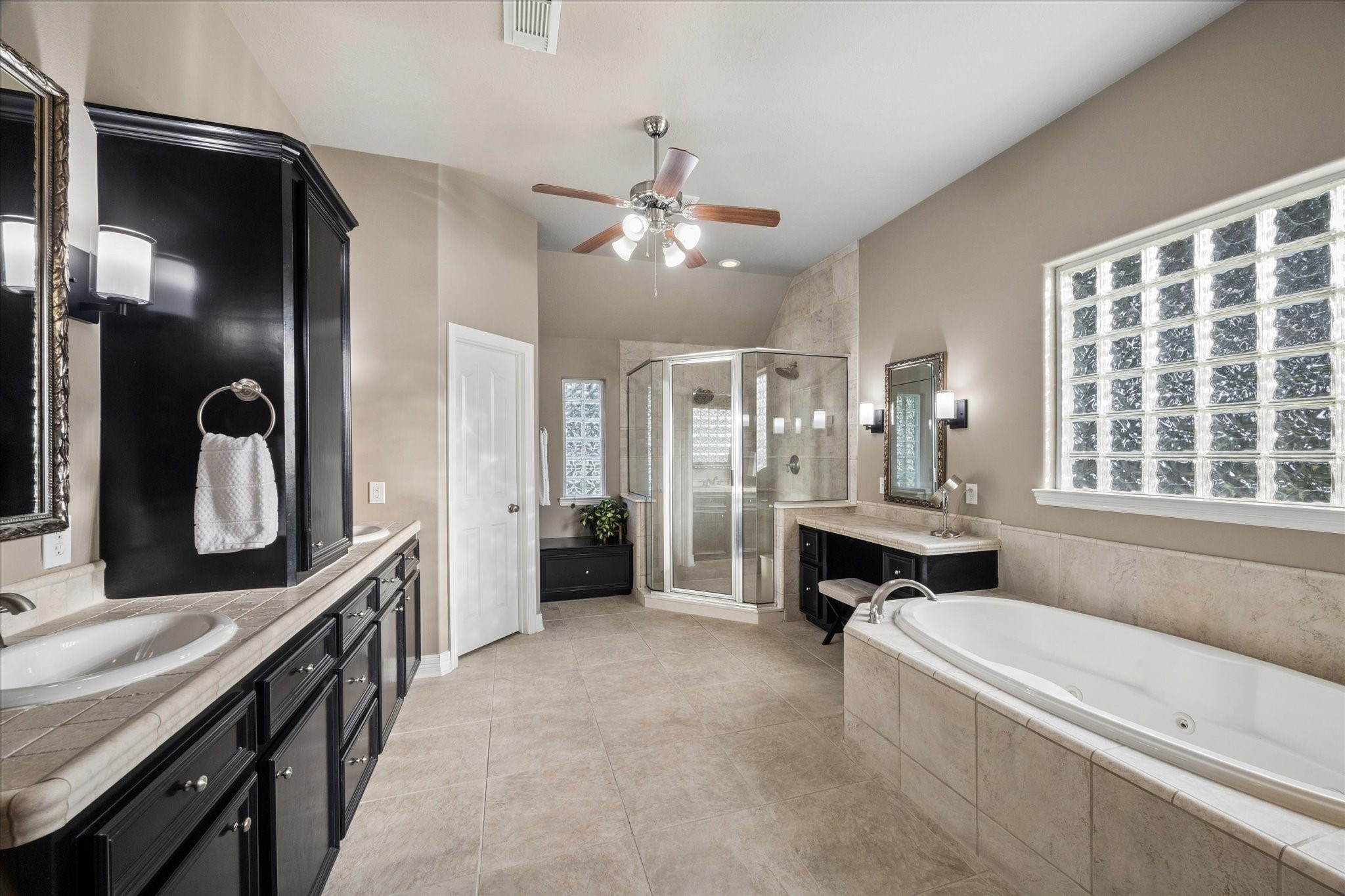 16519 Deerhaven Run Rosharon, TX 77583 - Photo 15 of 47 a bathroom with a double vanity sink a large mirror and a bathtub