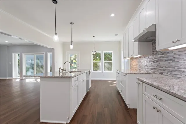 a kitchen with stainless steel appliances granite countertop a sink stove and wooden floor