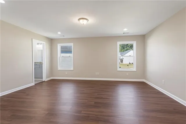 an empty room with wooden floor and window