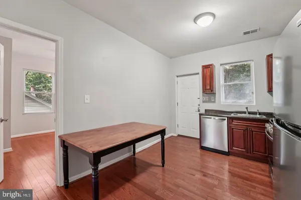 a kitchen with granite countertop a stove and wooden floor