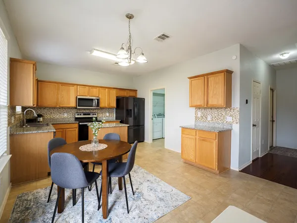 a large kitchen with a table and chairs in it