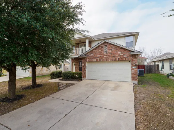 a front view of a house with yard and tree