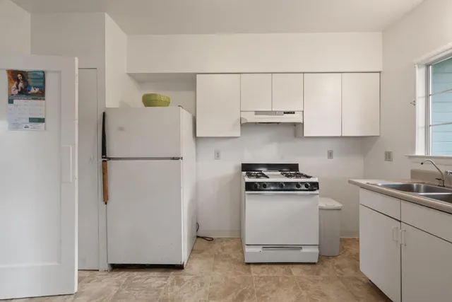 a kitchen with a refrigerator sink stove and cabinets