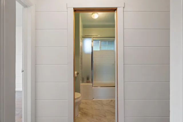 a bathroom with a glass shower door and mirror