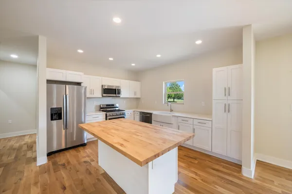 a kitchen with stainless steel appliances granite countertop a refrigerator and a stove top oven